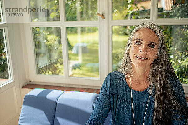 Happy mature woman with gray hair at home