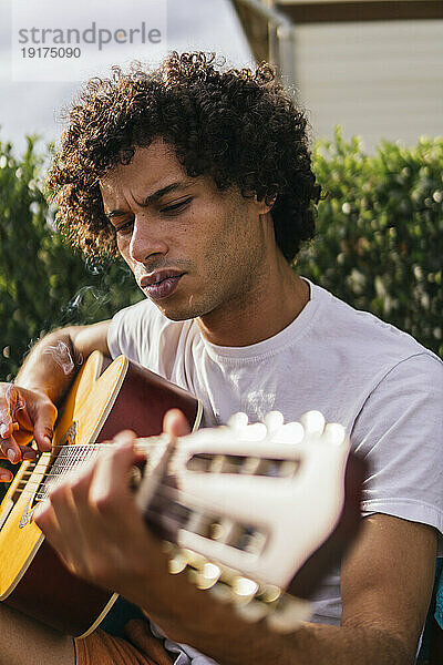 Mann spielt an einem sonnigen Tag Gitarre