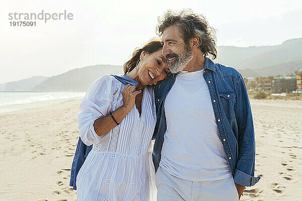 Cheerful woman embracing man at beach