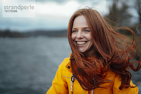 Happy redhead woman wearing yellow jacket