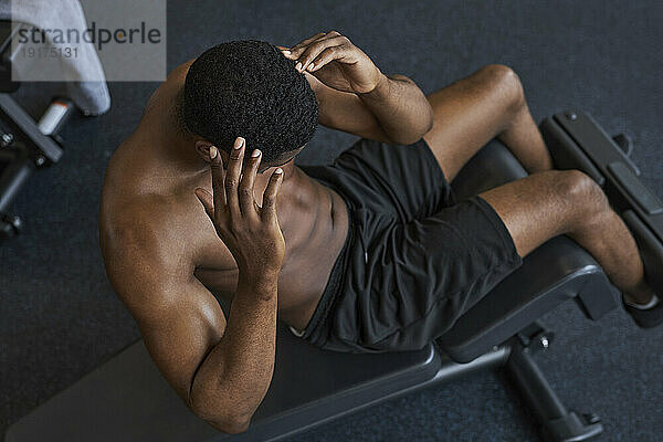 Man doing curl up exercise in gym