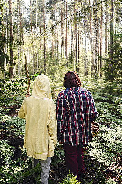 Junge mit Großmutter geht im Wald spazieren