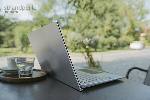 Laptop auf Tisch im Garten