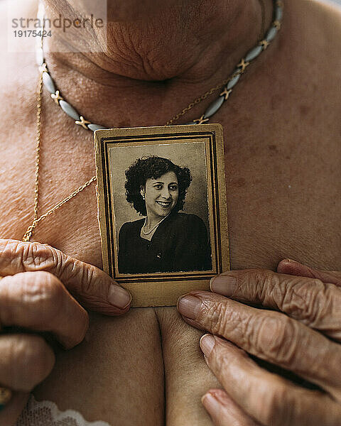 Ältere Frau hält ein Bild aus der Vergangenheit auf der Brust