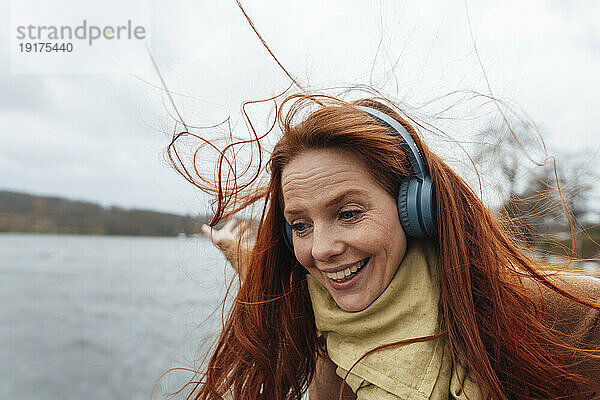 Happy redhead woman enjoying listening to music