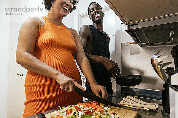 Glückliches Paar  das Gemüse in der Küche hackt