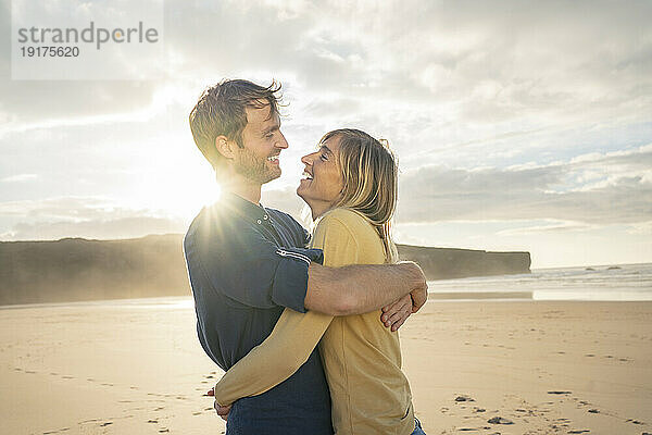 Lächelndes Paar  das sich an einem sonnigen Tag umarmt