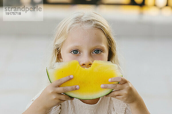 Mädchen hält ein Stück gelbe Wassermelone in ihren Händen
