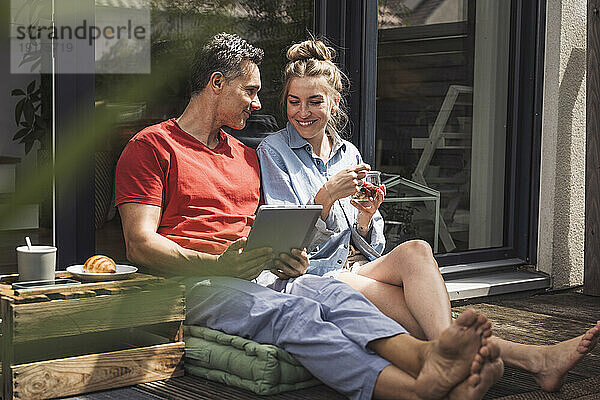Paar entspannt sich auf Balkon mit digitalem Tablet