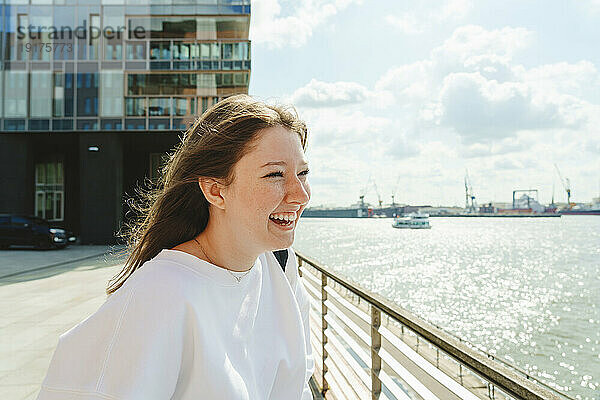 Fröhliches Teenager-Mädchen genießt das Wochenende an der Elbe im Hafen