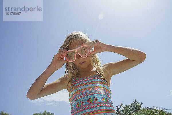 Mädchen trägt an einem sonnigen Tag eine Schwimmbrille