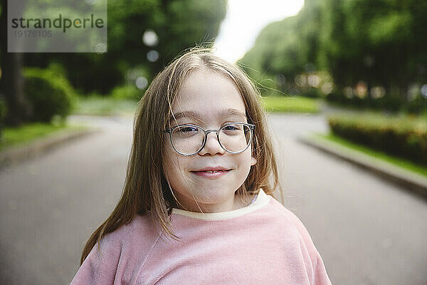 Smiling girl with eyeglasses in park