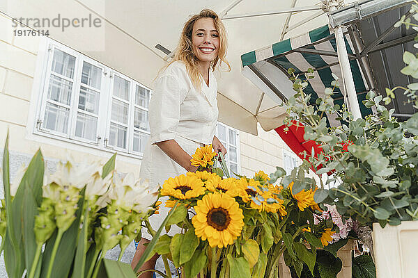 Glückliche Frau kauft Sonnenblumen auf dem Markt