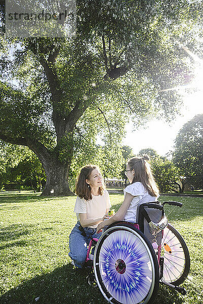 Tochter im Rollstuhl mit Mutter im Park