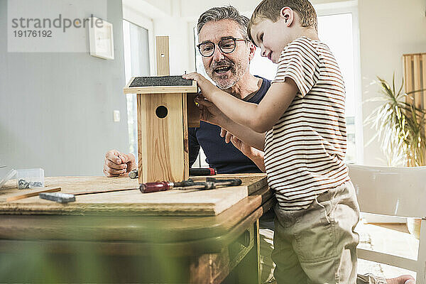 Mann baut Vogelhaus mit Enkel zu Hause