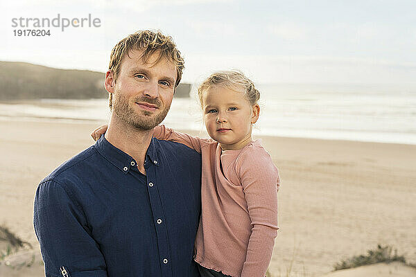 Lächelnder Vater und Tochter am Strand