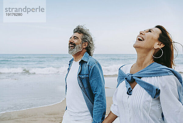 Älteres Paar lacht und genießt das Wochenende am Strand