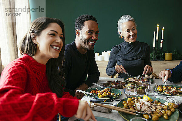 Lächelnde Familie beim gemeinsamen Abendessen im Esszimmer