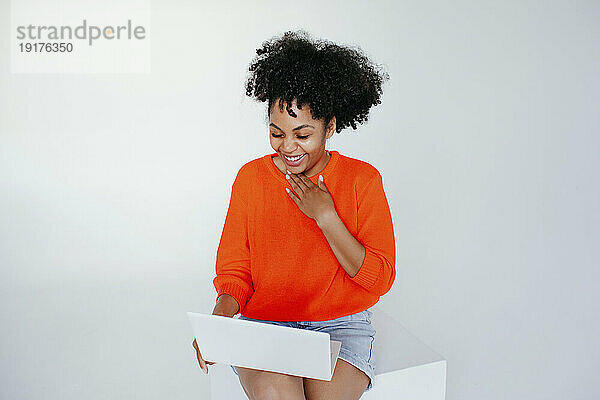Happy young woman using laptop against white background