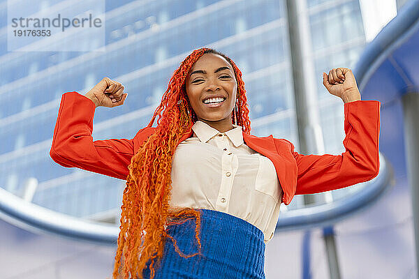 Lächelnde Geschäftsfrau feiert Erfolg im Büropark