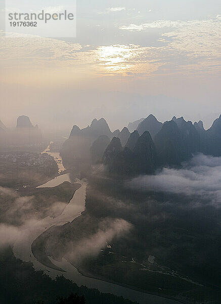 Berggipfel unter bewölktem Himmel bei Sonnenaufgang  Guilin  China