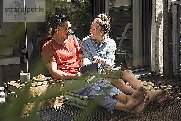 Paar entspannt sich auf Balkon mit digitalem Tablet