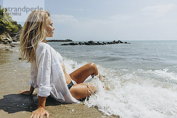 Frau mit geschlossenen Augen entspannt sich am Strand