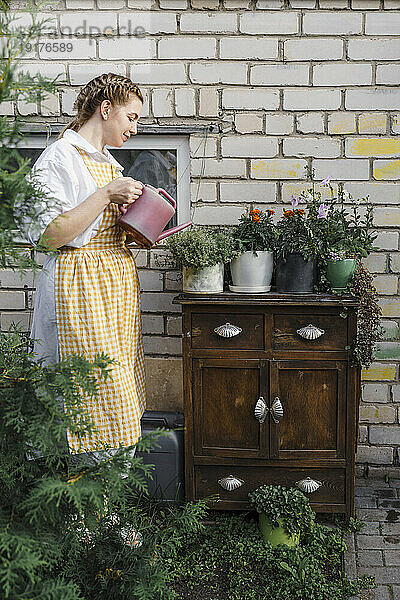 Frau gießt Pflanzen im Garten