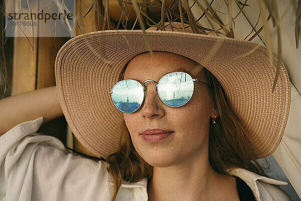 Frau mit Sonnenbrille und Hut im Urlaub