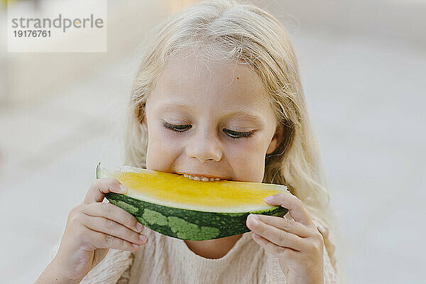 Mädchen isst frische gelbe Wassermelone