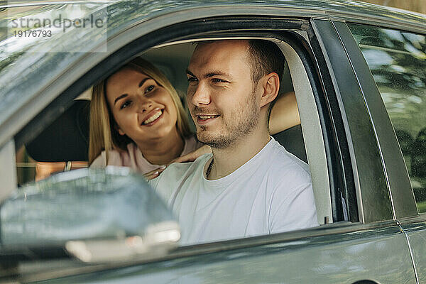 Lächelndes Paar sitzt zusammen im Auto