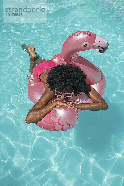 Frau entspannt sich auf Schwimmkörper im Pool