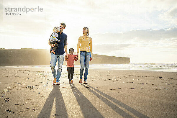 Glückliche Familie genießt gemeinsam einen sonnigen Tag am Strand
