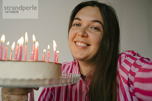 Lächelnde Frau mit Geburtstagstorte