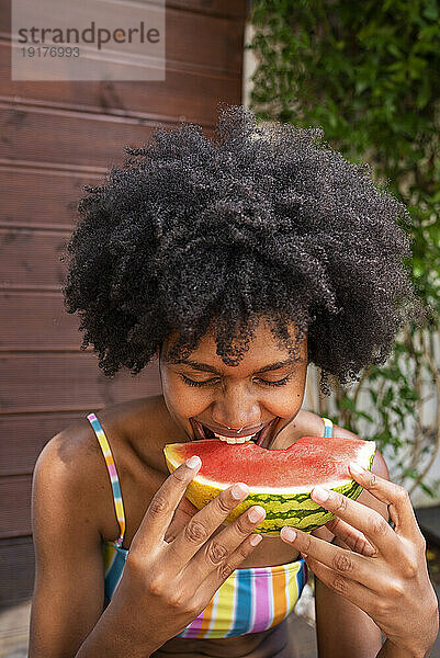 Cheerful woman eating watermelon at vacations