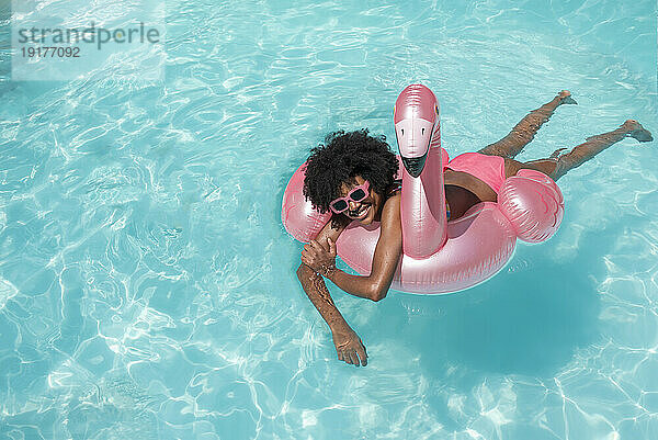 Smiling young woman swimming with inflatable ring