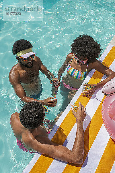 Fröhliche Freunde genießen die Poolparty im Resort