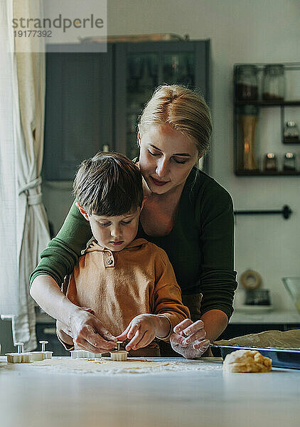 Mutter und Sohn bereiten in der Küche Lebkuchenplätzchen zu