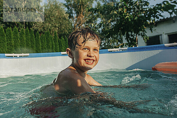 Glücklicher Junge schwimmt im Planschbecken