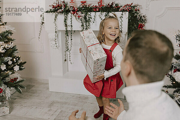 Lächelnde Tochter hält Weihnachtsgeschenk