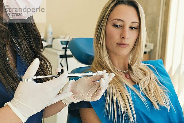 Zahnarzt bereitet Anästhesie in der Zahnarztpraxis vor  im Hintergrund sieht der Patient die Injektion mit Beklemmung. Selektiver Fokus