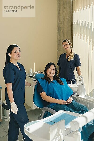 Porträt von drei Frauen  Zahnärztin  Assistentin und Patientin in einer Zahnarztpraxis  die lächelnd in die Kamera schauen. Konzept der Zahngesundheit