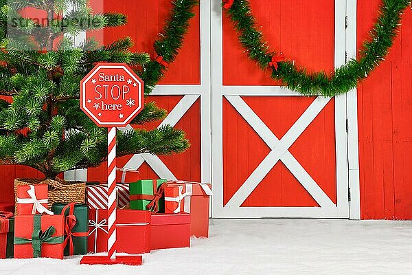 Weihnachten Hintergrund mit Santa Stopschild Geschenkboxen Weihnachtsbaum vor der hölzernen roten Tür mit Girlanden