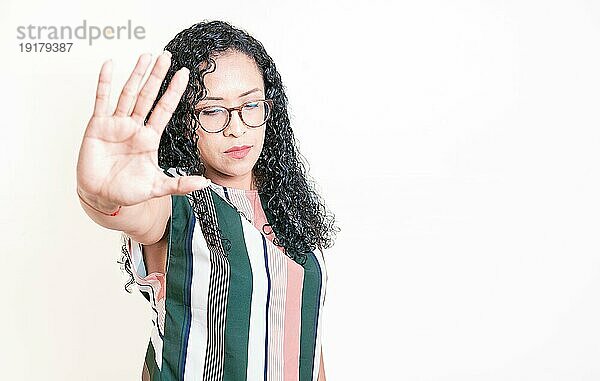 Latino Mädchen gestikuliert mit Handfläche Stopp. Frau mit Brille lehnt mit der Handfläche ab