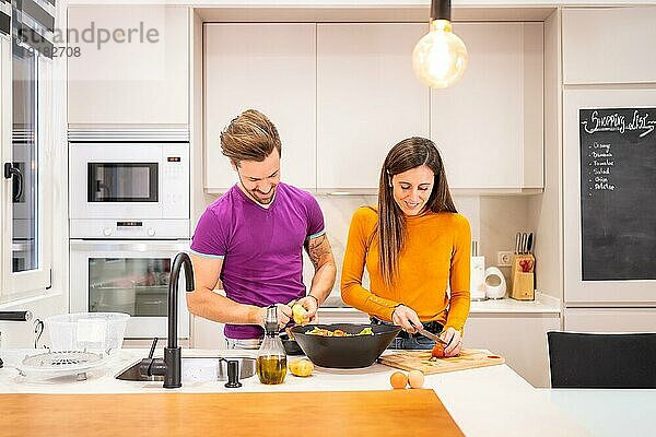 Foto mit Kopiervorlage eines Paares in der Küche  das gemeinsam einen Salat zubereitet