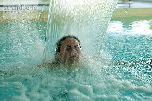 Frau Gesicht entspannen in einem Hydromassage Pool mit fallendem Wasser in langer Belichtung in der Schweiz