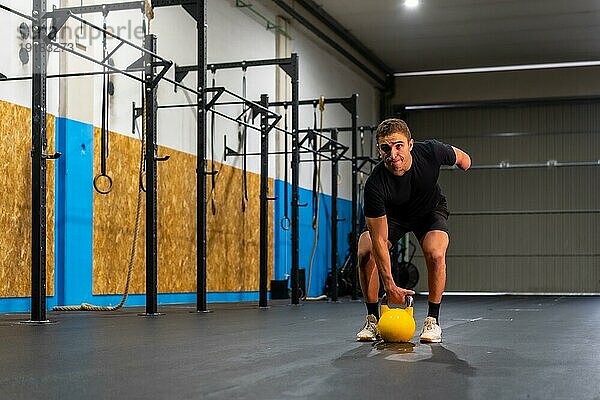 Foto mit Kopierbereich eines behinderten Mannes mit amputiertem Arm  der mit einer Kettlebell trainiert