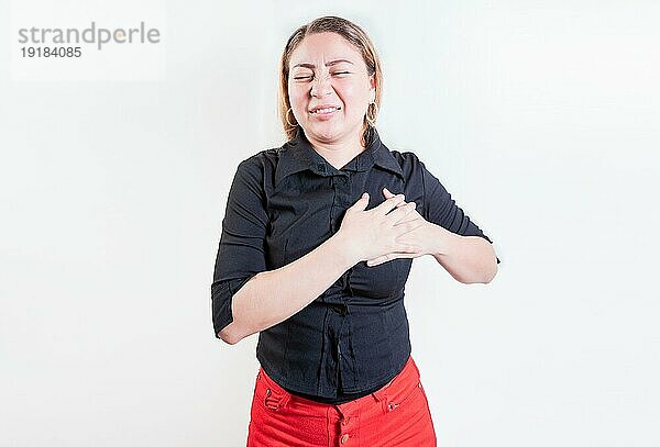 Lateinische Frau mit Herzschmerzen auf isoliertem Hintergrund. Junge Frau mit Tachykardie. Konzept der Menschen mit Herzproblemen