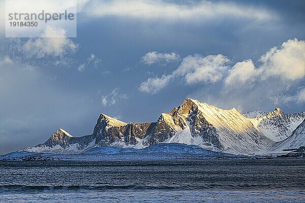 Blick von Fredvang auf verschneite Berge entlang der Küste  Lofoten  Norwegen  Europa