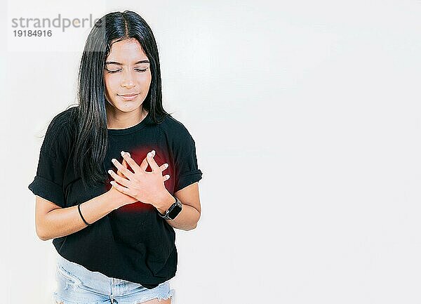 Junge Frau mit Tachykardie. Konzept von Menschen mit Herzproblemen. Lateinische Frau mit Herzschmerzen auf isoliertem Hintergrund